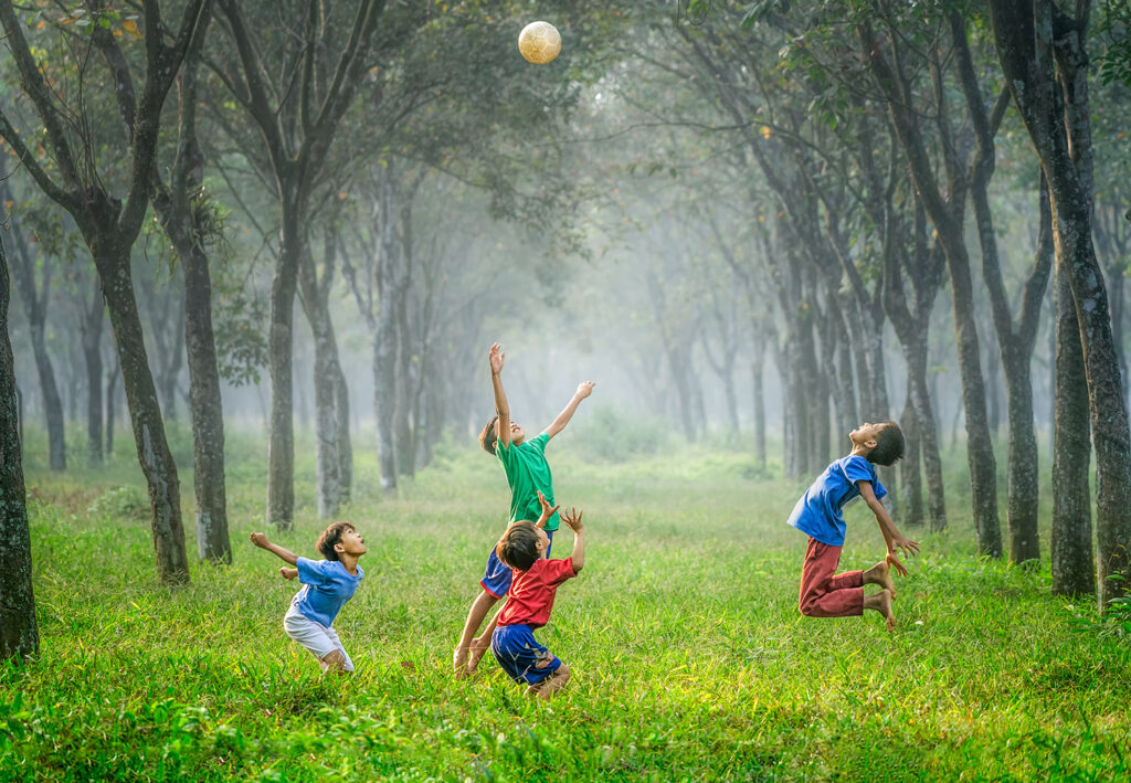 Boys playing soccer in field